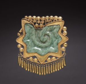 This unusual pendant comprises a polished jade plaque carved in the shape of the cross section of a conch shell and a delicate gold frame with tiny dangling bells. The cut conch was a jewel worn by Quetzalcoatl (Feathered Serpent), an Aztec culture hero and supernatural creature closely associated with the wind that brings rain clouds and new life. 
