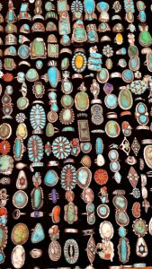 A display of Native American rings made of turquoise, coral and other gems
